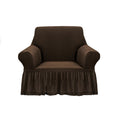 Coffee brown 1-seater sofa cover with ruffled skirt draped over an armchair in a living room.