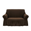 Coffee brown two-seater high stretch sofa cover with ruffled skirt protecting a living room couch