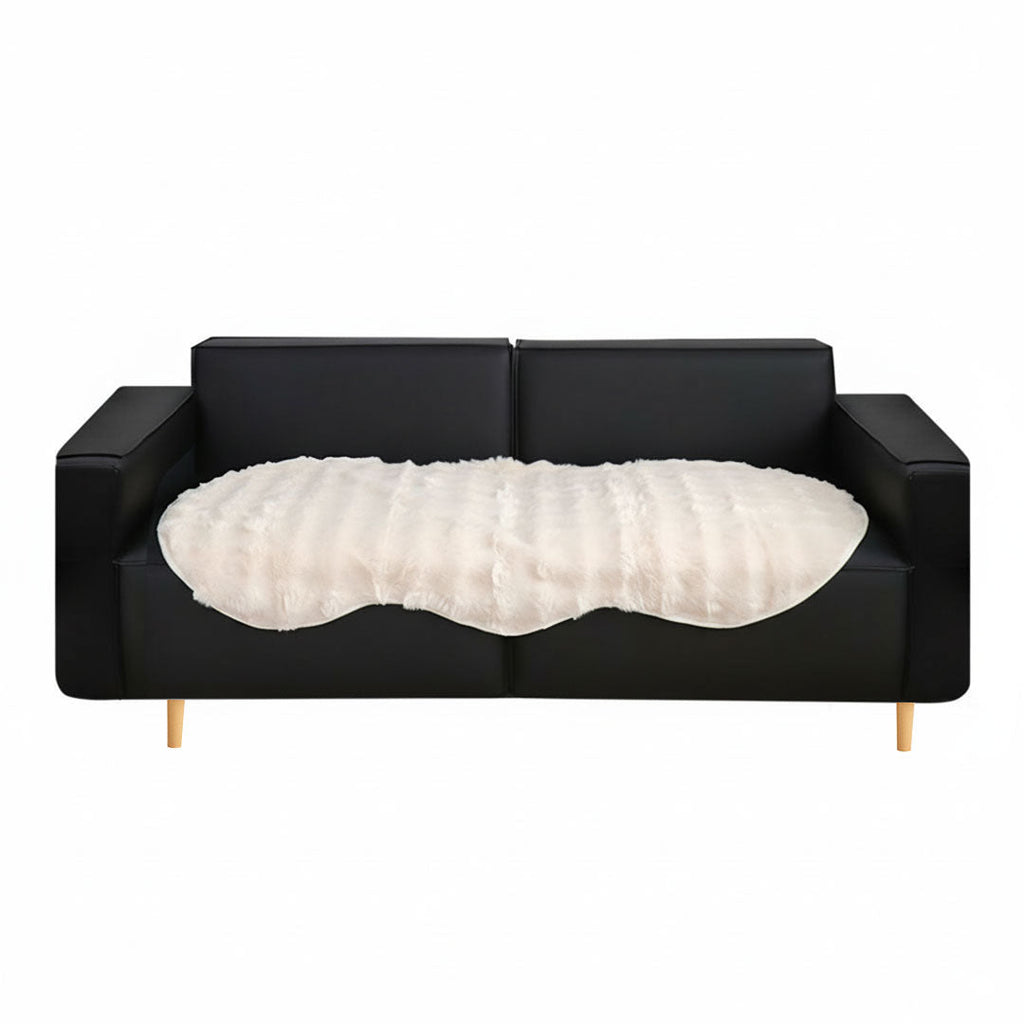 White faux fur throw blanket protecting a large four seater living room sofa