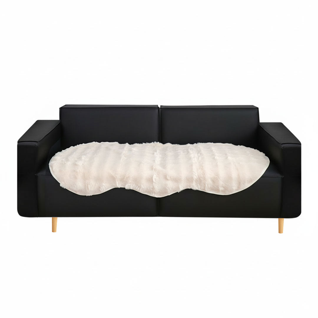 White faux fur throw blanket protecting a large four seater living room sofa