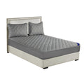 Grey cross-hatch quilted mattress cover and two matching pillowcases on a modern bed