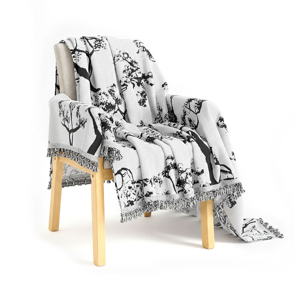 White tree print polyester three-seater sofa cover draped elegantly over a modern living room couch