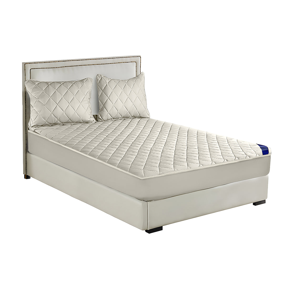 White quilted mattress cover and two matching pillow protectors displayed on a well-made comfortable bed