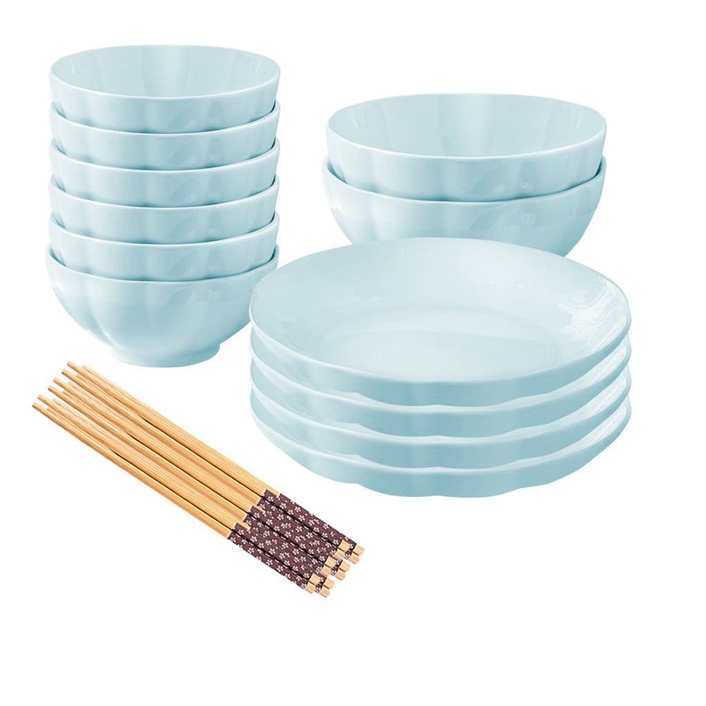 Light blue Japanese style ceramic dinnerware set with bowls plates and chopsticks on a table