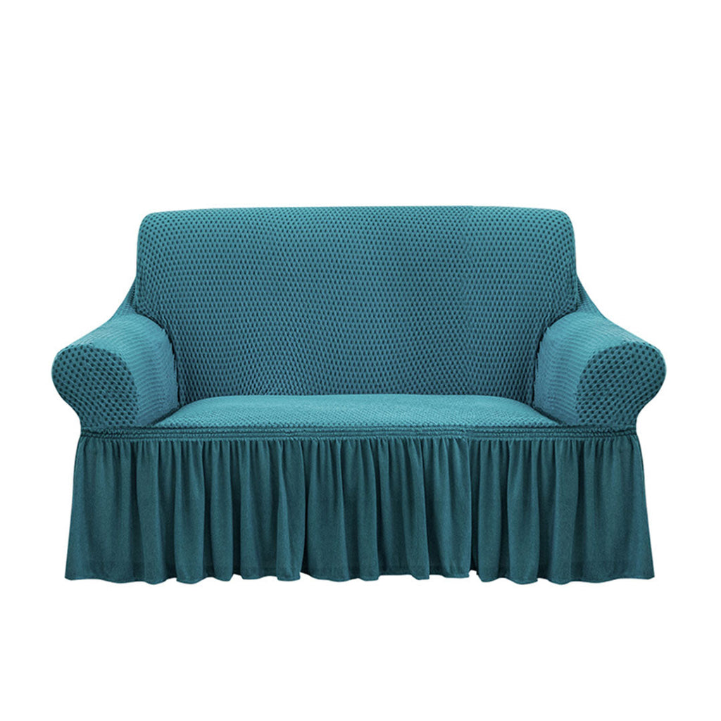 Blue high-stretch 2-seater sofa cover with elegant ruffled skirt protecting a living room couch