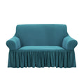 Blue high-stretch 2-seater sofa cover with elegant ruffled skirt protecting a living room couch