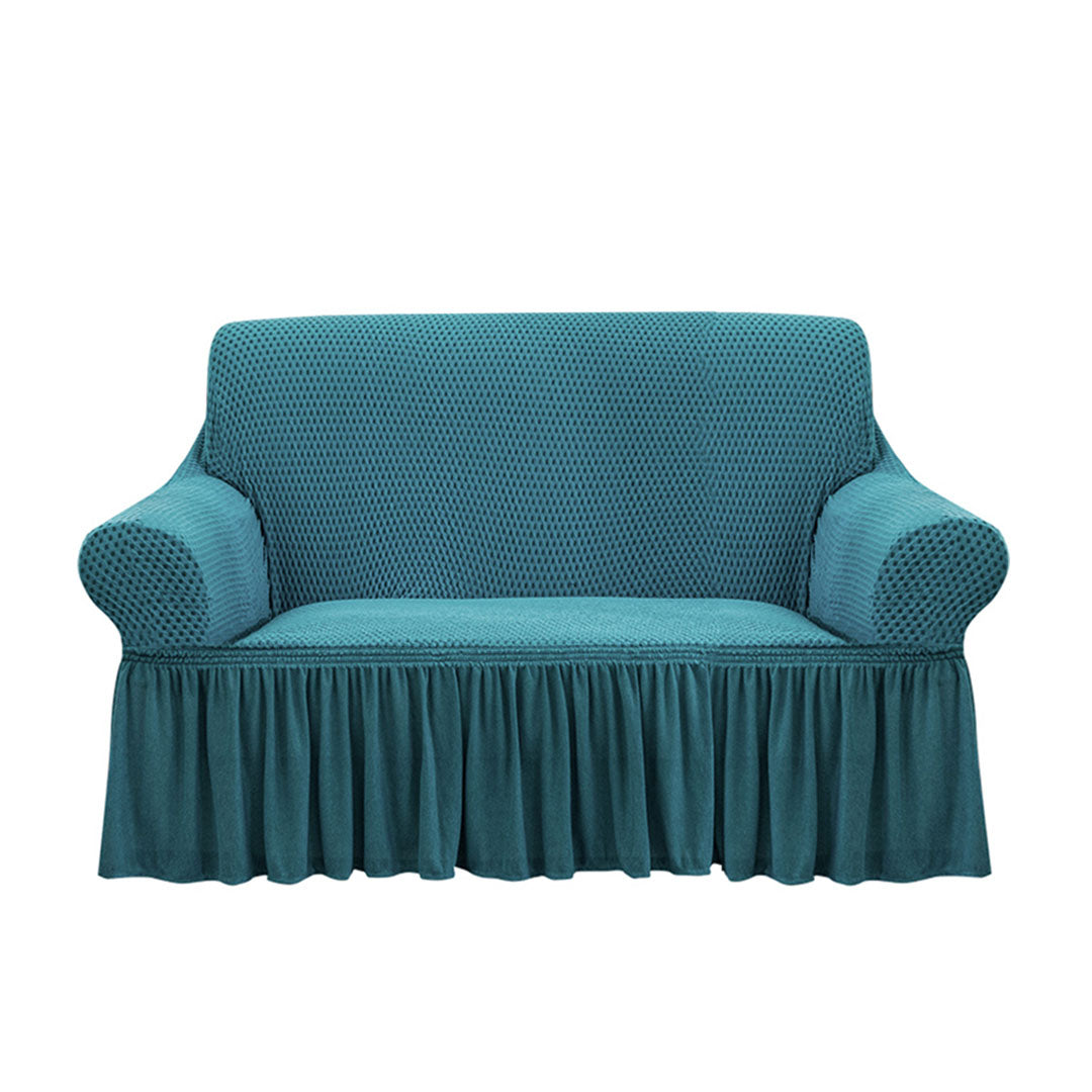 Blue high-stretch 2-seater sofa cover with elegant ruffled skirt protecting a living room couch