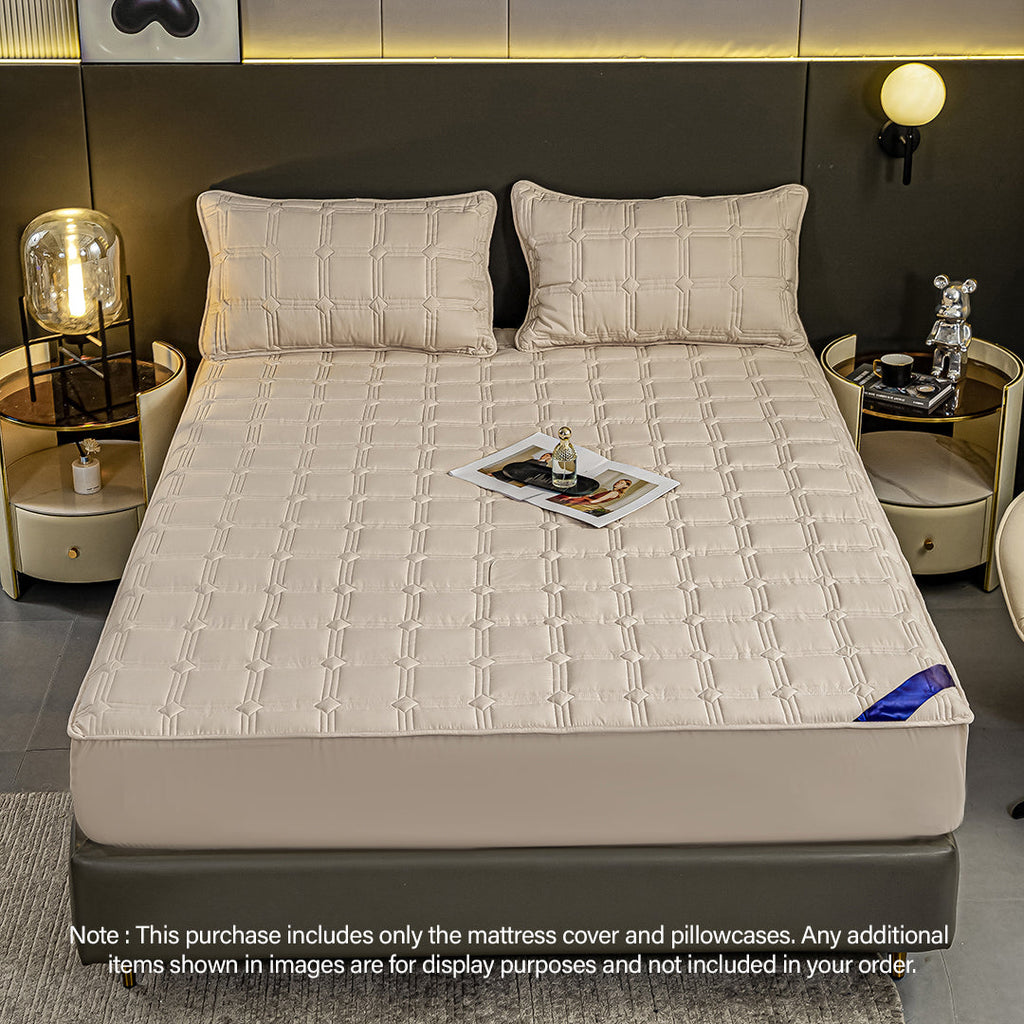 Beige quilted stretchable mattress cover and two matching pillow cases displayed on a bed. — view 2