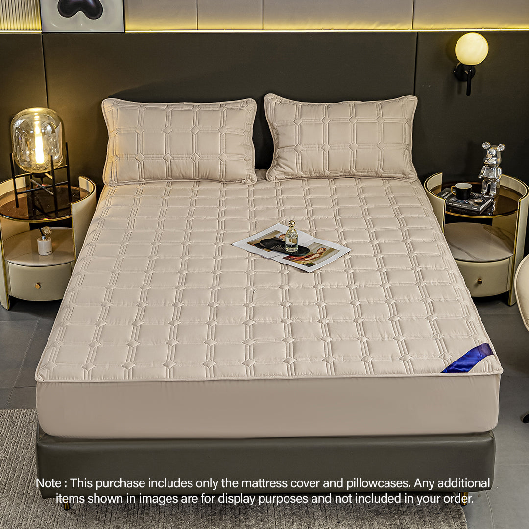 Beige quilted stretchable mattress cover and two matching pillow cases displayed on a bed. — view 2