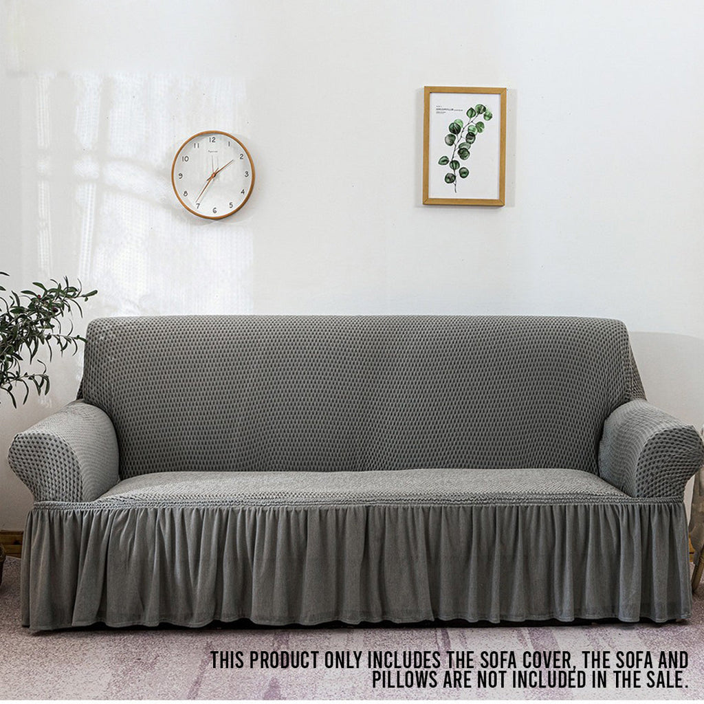 4-seater grey stretch sofa cover with ruffled skirt on a living room couch — view 2