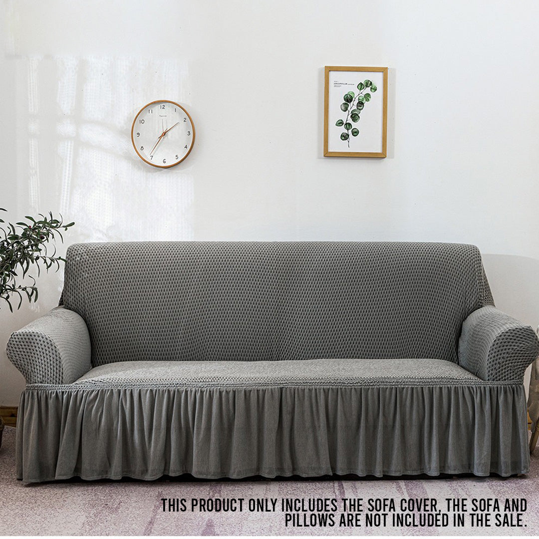 4-seater grey stretch sofa cover with ruffled skirt on a living room couch — view 2
