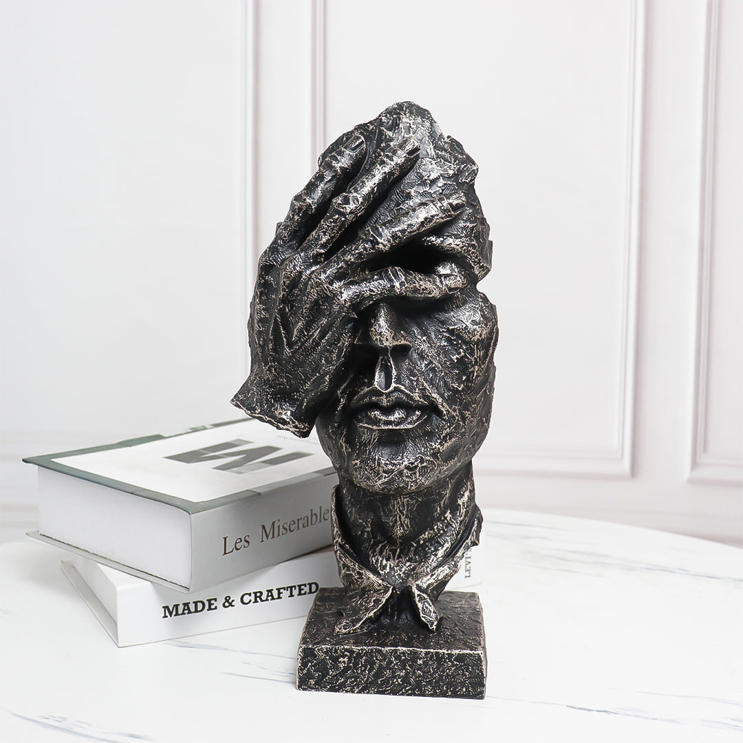 Abstract face sculpture in antique bronze black resin with a hand-over-eyes modern design. — view 2