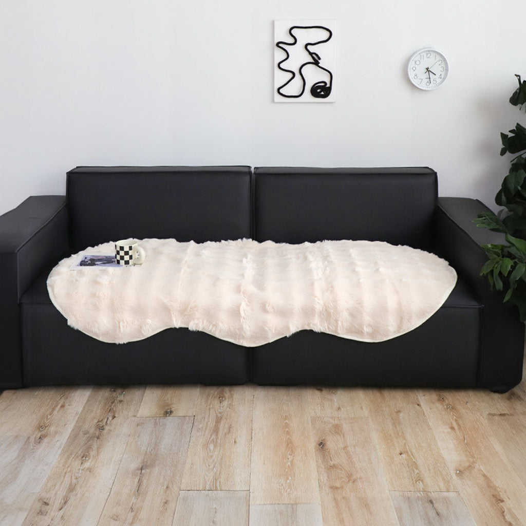 White faux fur throw blanket protecting a large four seater living room sofa — view 2