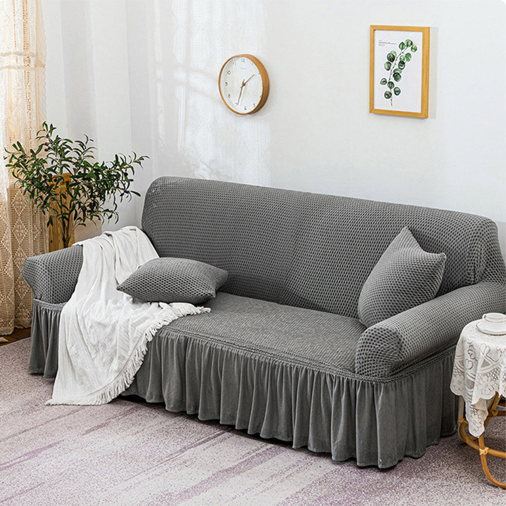 4-seater grey stretch sofa cover with ruffled skirt on a living room couch — view 3