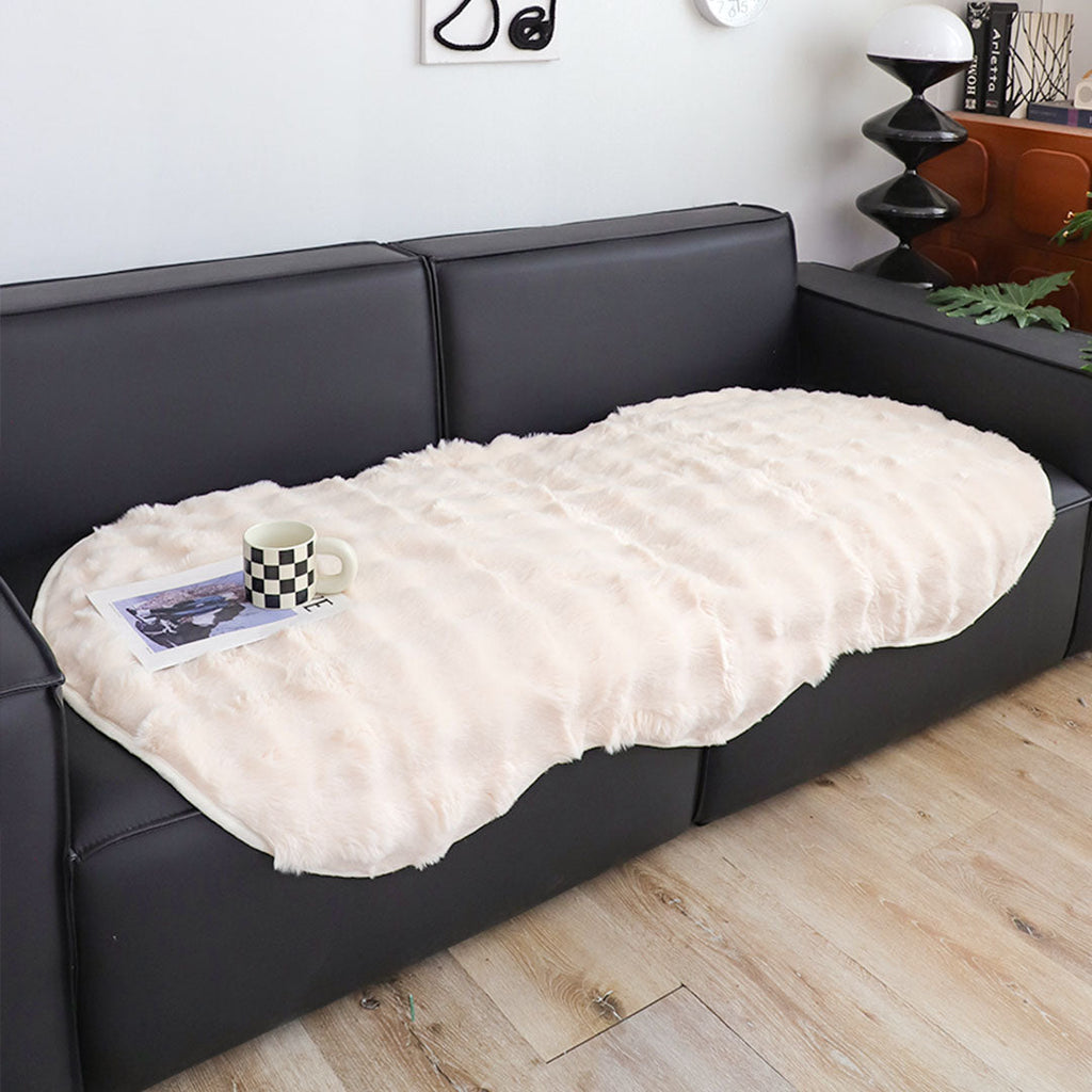 White faux fur throw blanket protecting a large four seater living room sofa — view 3