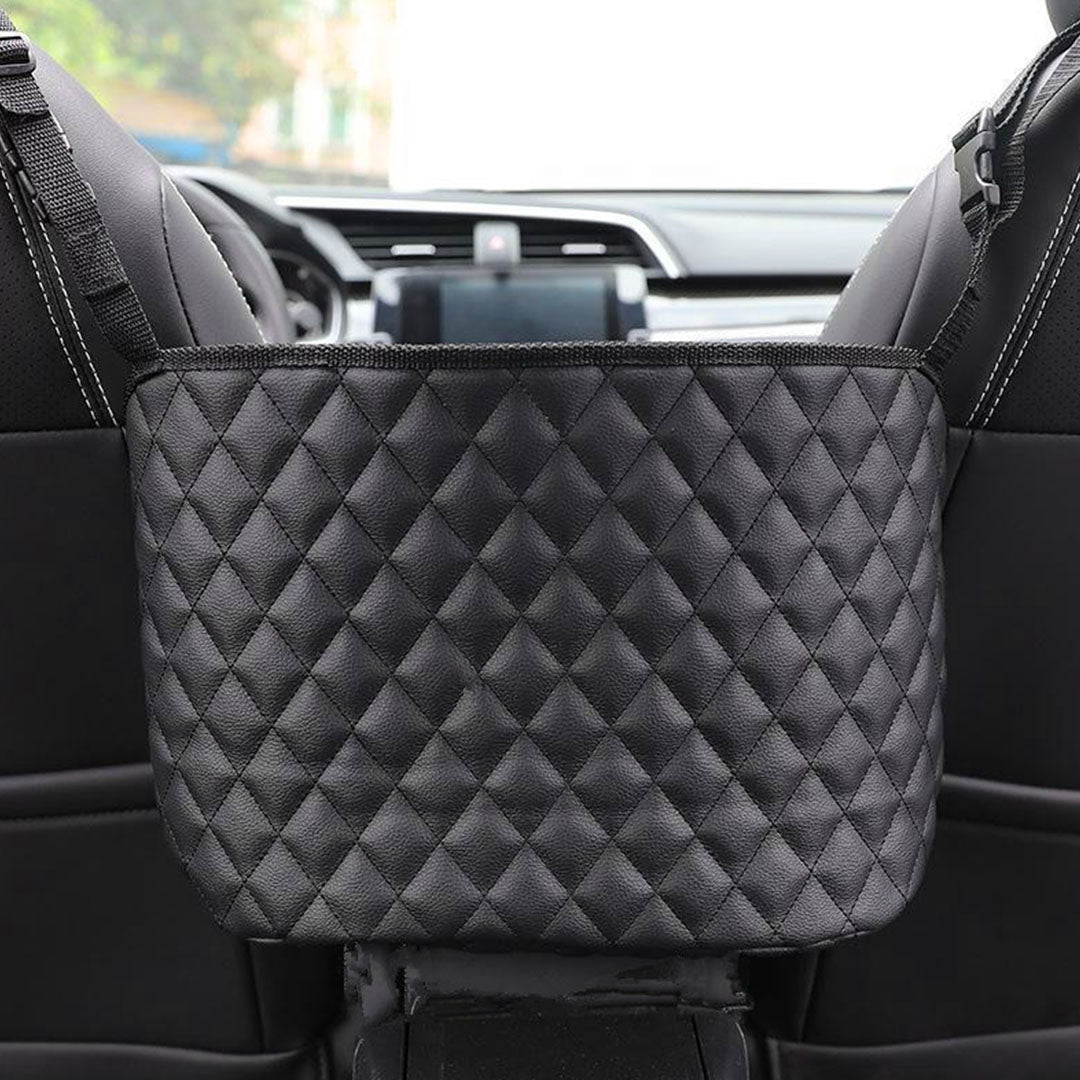 Black leather car organizer bag hanging between two front seats holding a purse and accessories — view 3