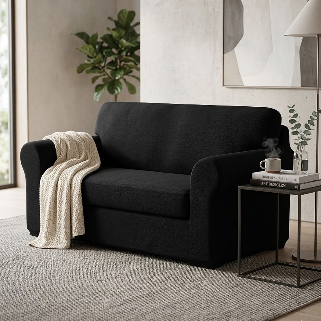 Black 2-seater high stretch sofa cover protecting a living room couch from spills and stains — view 4