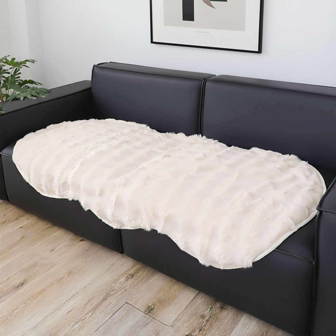 White faux fur throw blanket protecting a large four seater living room sofa — view 4