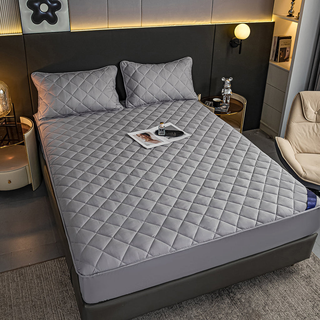 Grey cross-hatch quilted mattress cover and two matching pillowcases on a modern bed — view 4
