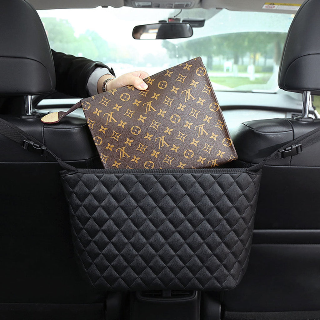 Black leather car organizer bag hanging between two front seats holding a purse and accessories — view 4