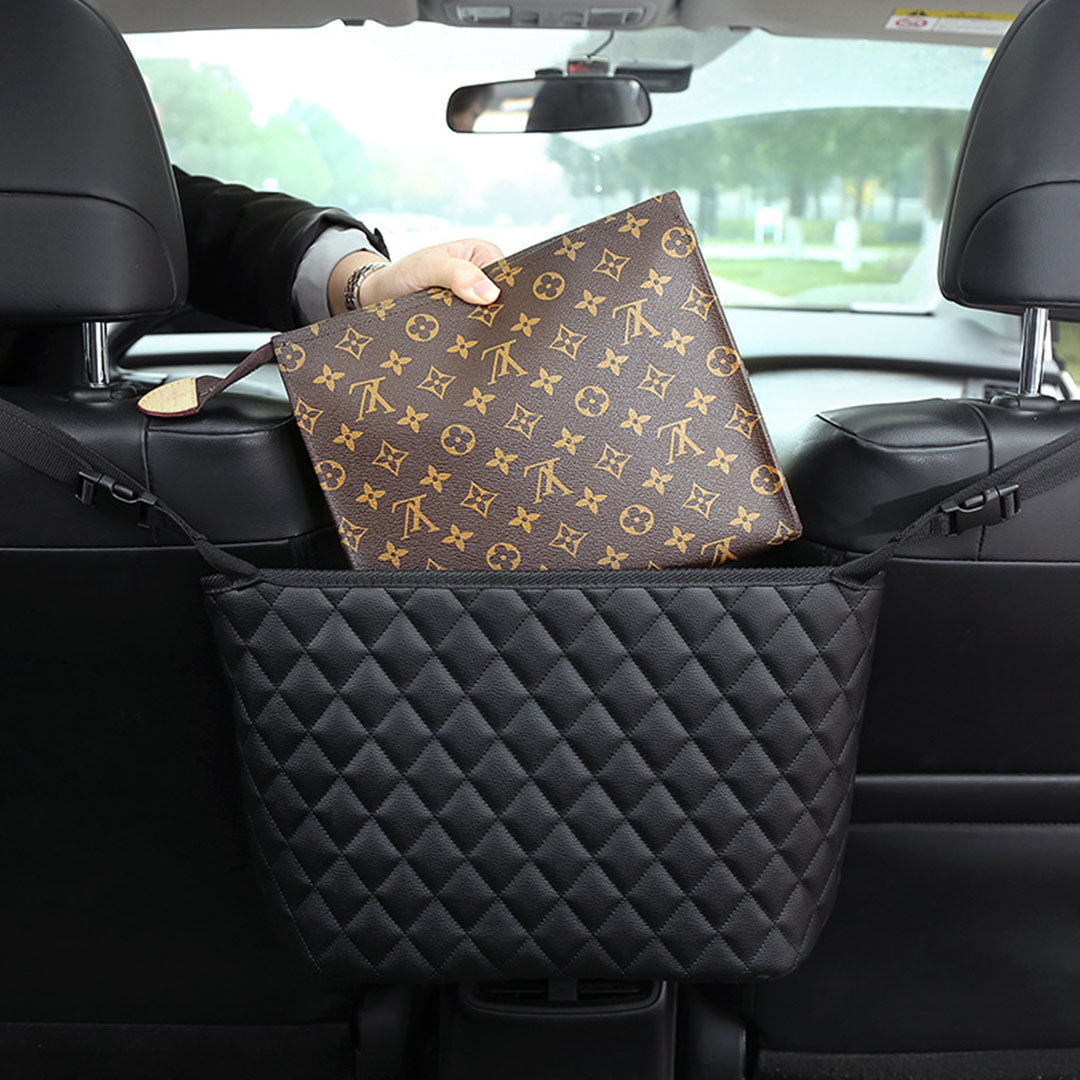 Black leather car organizer bag hanging between two front seats holding a purse and accessories — view 4