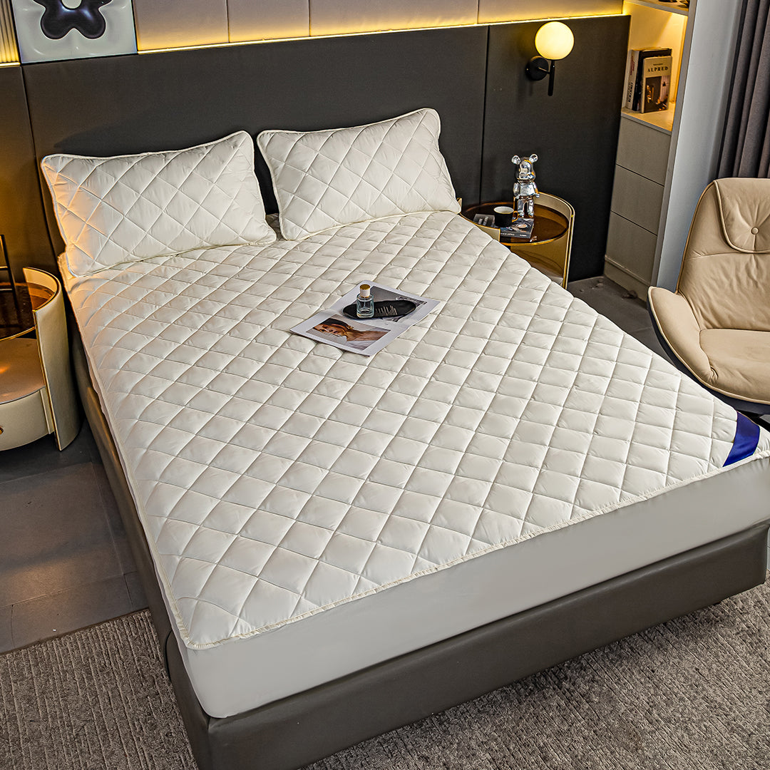 White quilted mattress cover and two pillowcases on a bed, premium polyester stretchable bed protector — view 4