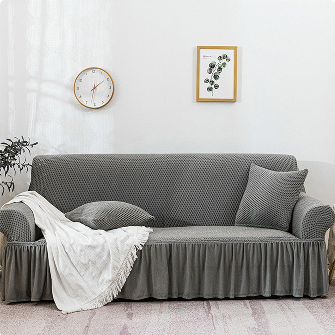 4-seater grey stretch sofa cover with ruffled skirt on a living room couch — view 4