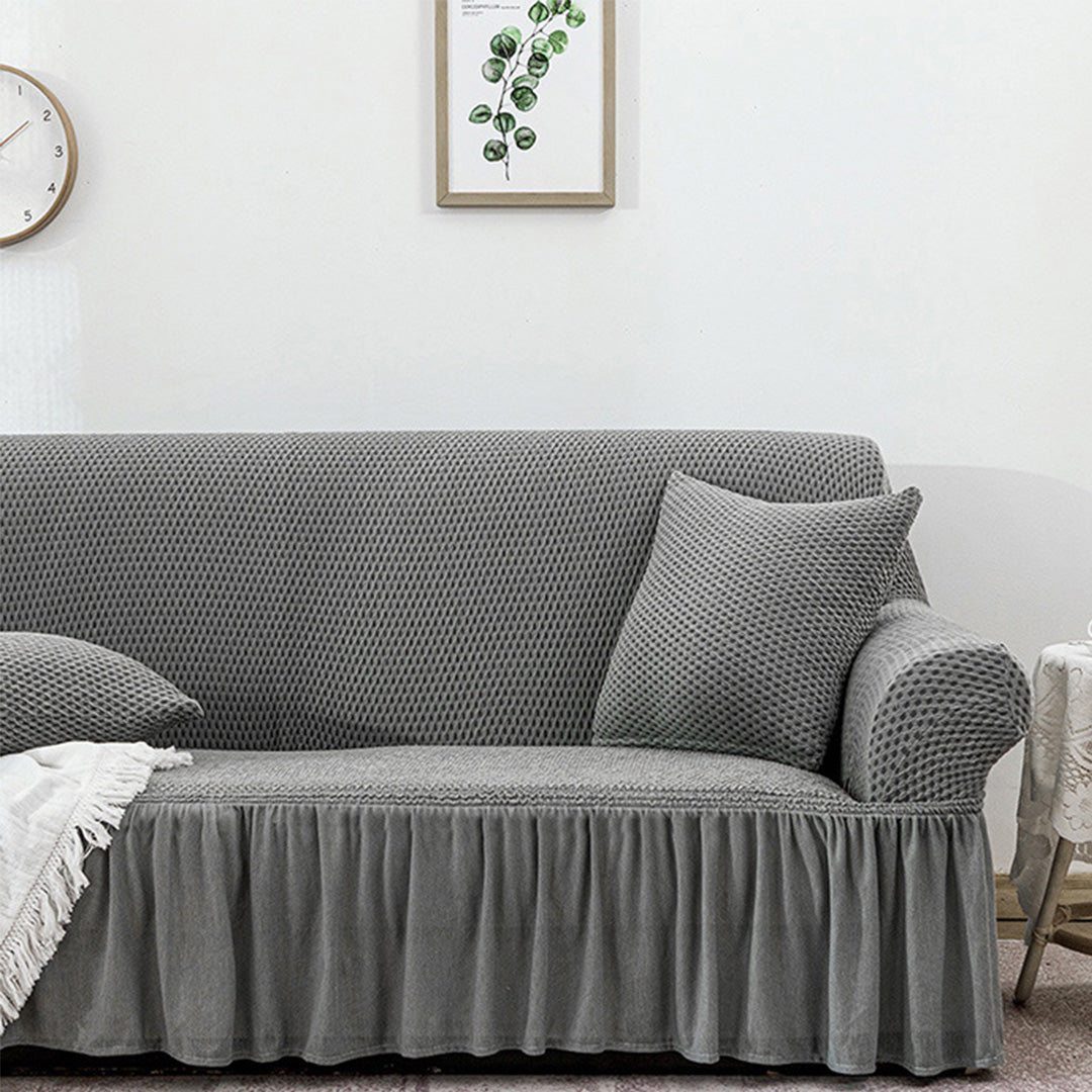 4-seater grey stretch sofa cover with ruffled skirt on a living room couch — view 5