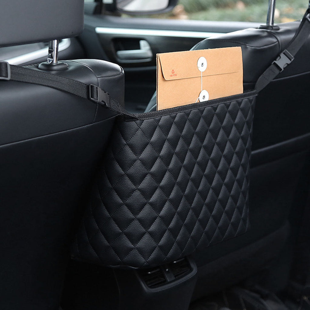 Black leather car organizer bag hanging between two front seats holding a purse and accessories — view 5
