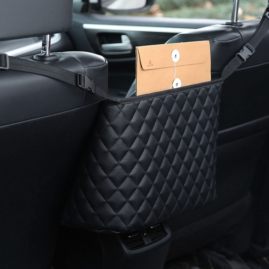 Black leather car organizer bag hanging between two front seats holding a purse and accessories — view 5