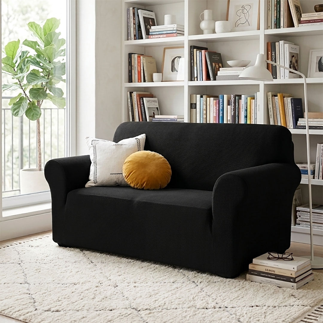 Black 2-seater high stretch sofa cover protecting a living room couch from spills and stains — view 5