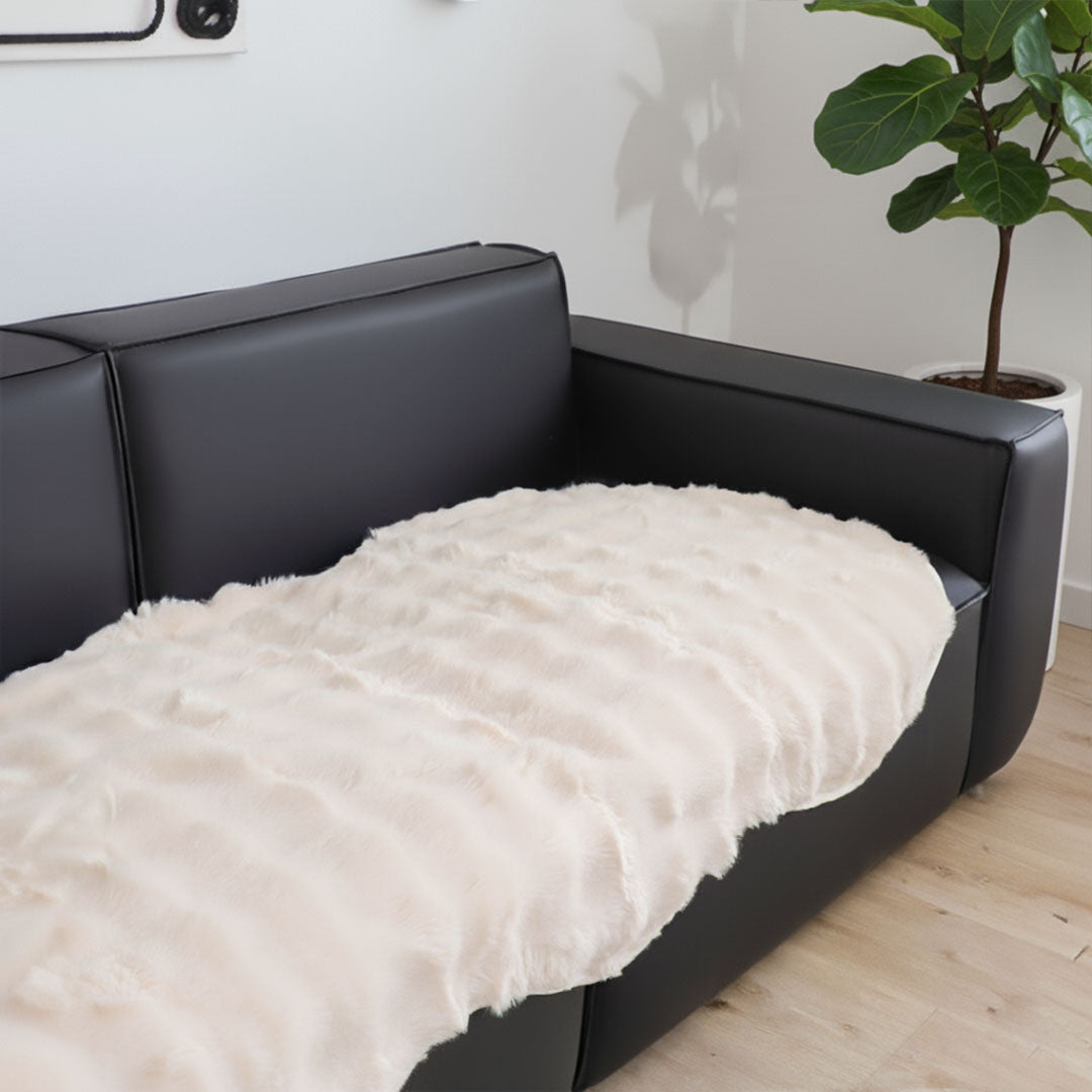 White faux fur throw blanket protecting a large four seater living room sofa — view 5