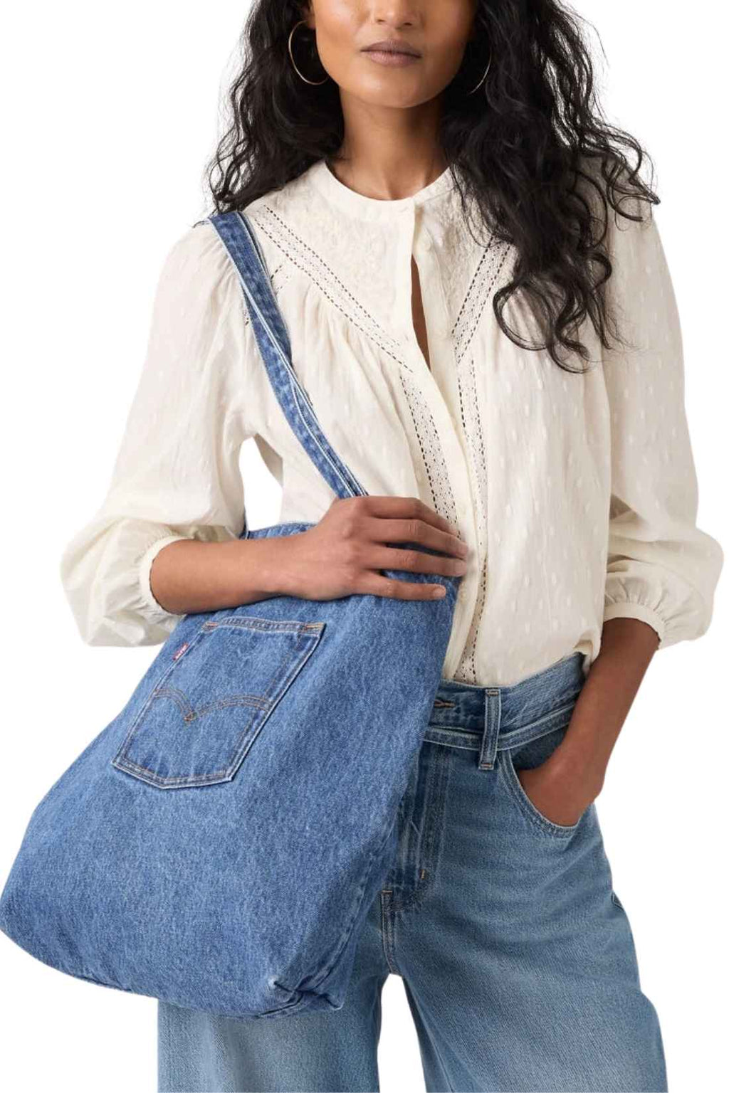 Beige denim tote bag with double handles, snap fastening, front pocket, and red signature label — view 7