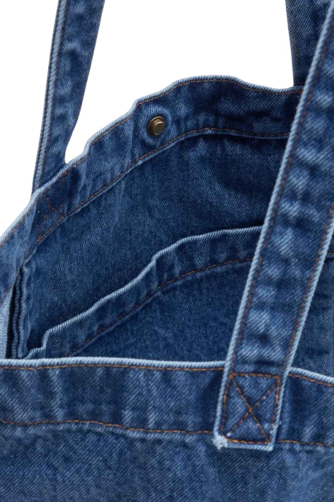 Beige denim tote bag with double handles, snap fastening, front pocket, and red signature label — view 5