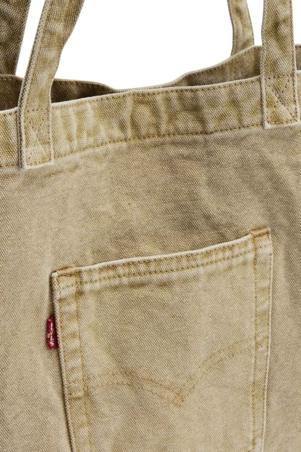 Beige denim tote bag with double handles, snap fastening, front pocket, and red signature label — view 24