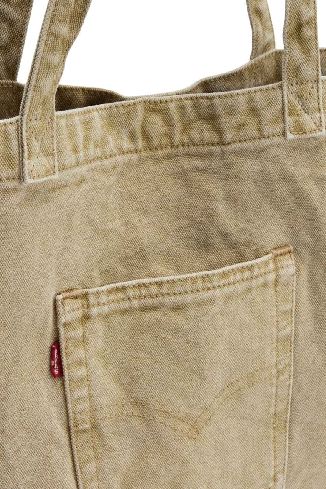 Beige denim tote bag with double handles, snap fastening, front pocket, and red signature label — view 24
