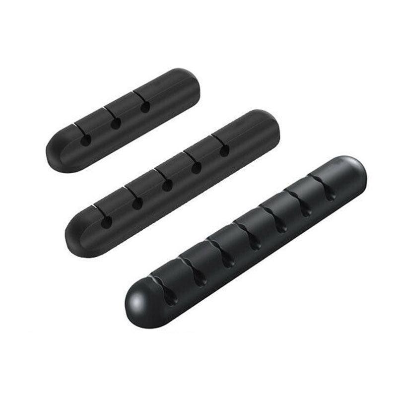 Silicone desk cable organizer clips holding various USB and charging cords on a flat surface — view 2