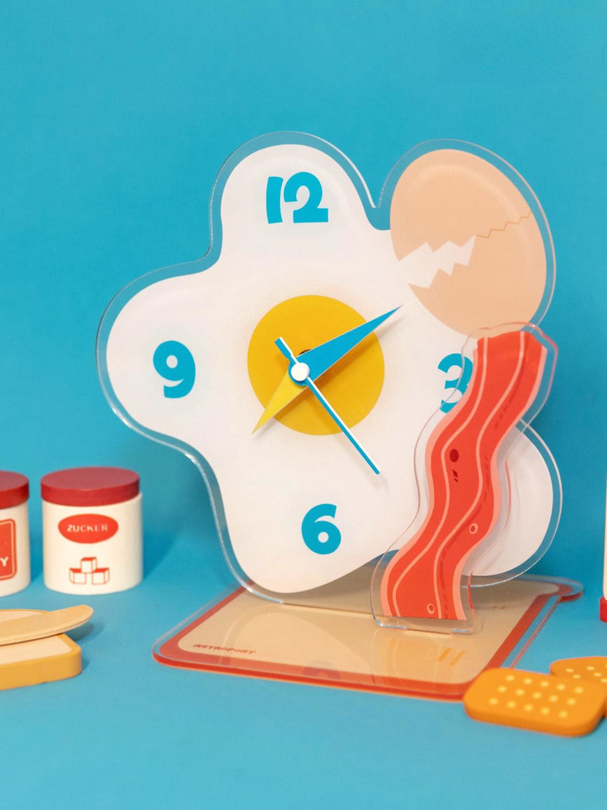 Egg shaped acrylic desktop clock displaying time on a modern home office desk surface — view 3