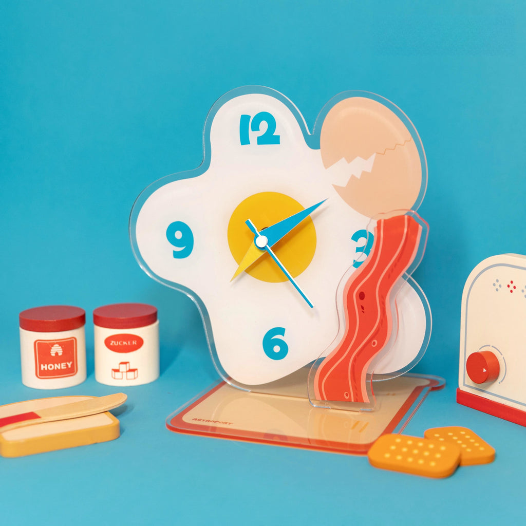 Egg shaped acrylic desktop clock displaying time on a modern home office desk surface