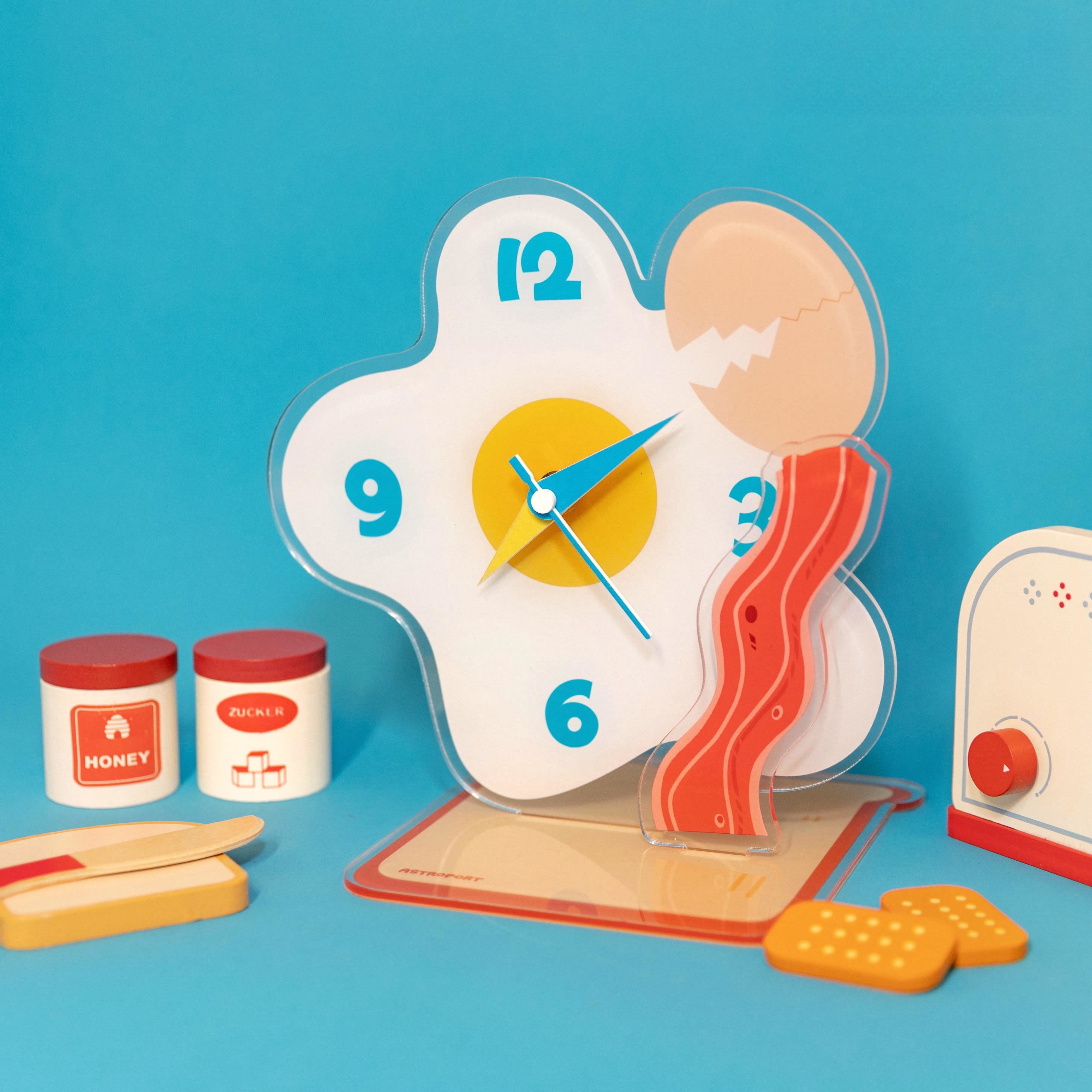 Egg shaped acrylic desktop clock displaying time on a modern home office desk surface