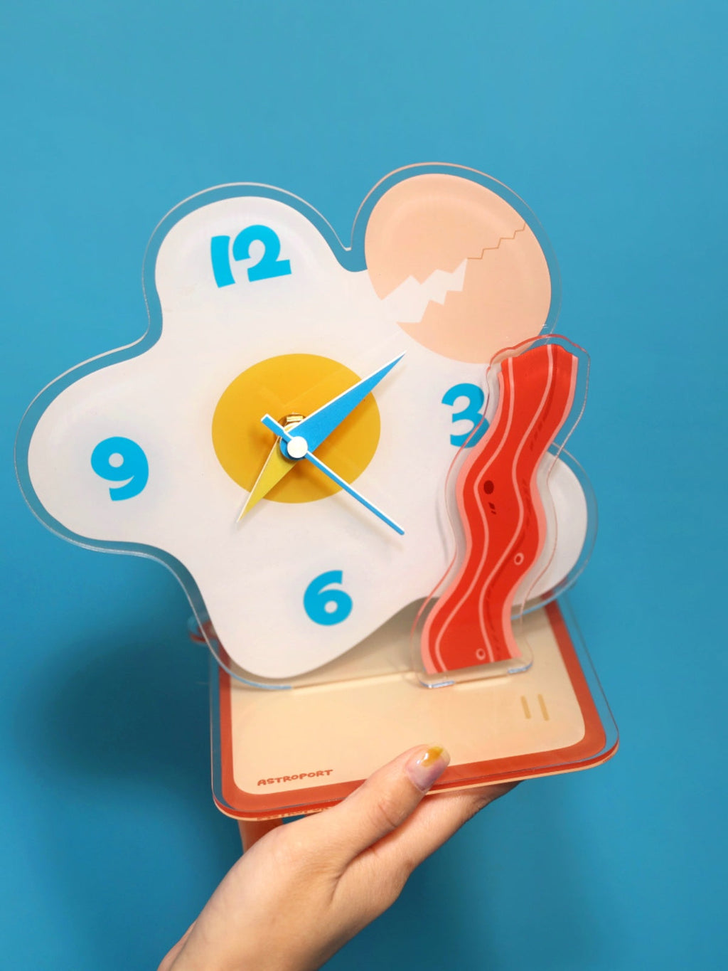 Egg shaped acrylic desktop clock displaying time on a modern home office desk surface — view 4