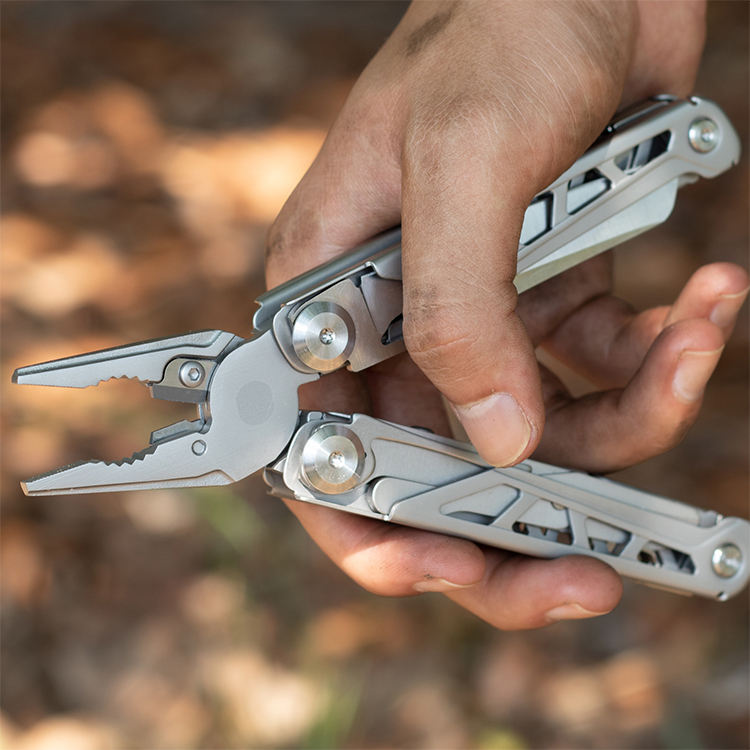 Stainless steel foldable multitool with open pliers scissors screwdriver and saw on a white background — view 3