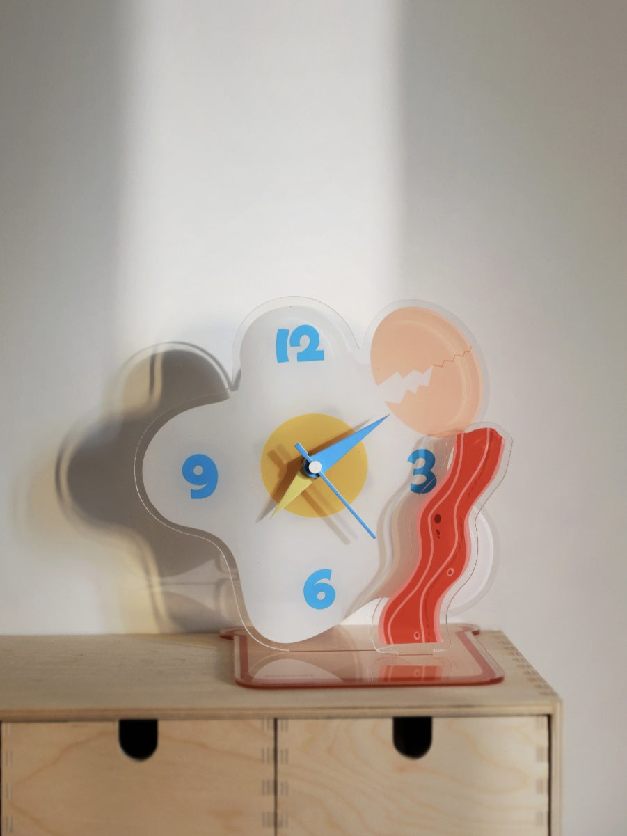 Egg shaped acrylic desktop clock displaying time on a modern home office desk surface — view 5
