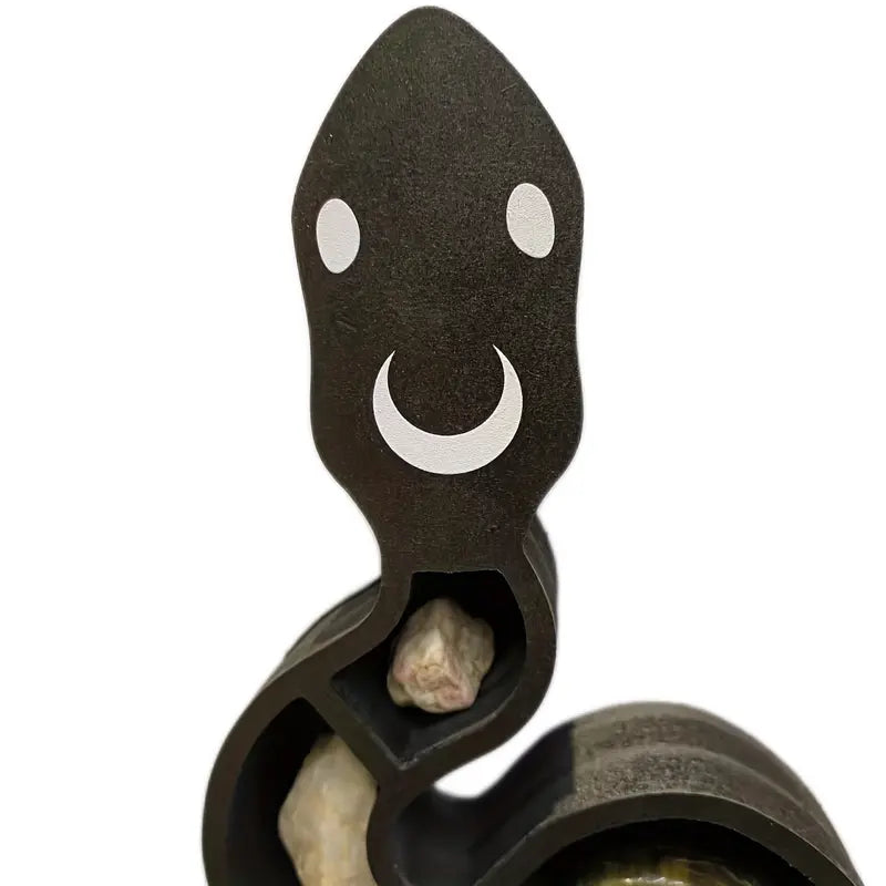 Black wooden snake shaped wall shelf displaying crystals and small plants on a wall — view 4