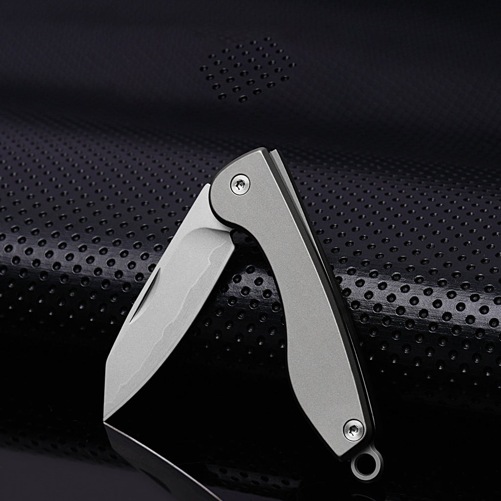 Mini folding titanium utility knife with a razor-sharp stainless steel blade and compact keychain loop