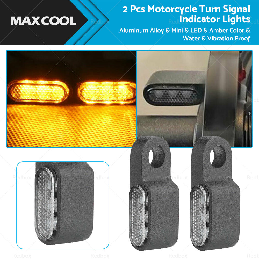 Two black aluminum mini LED motorcycle turn signals emitting bright amber blinker light. — view 3