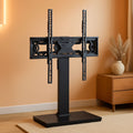 Universal TV stand with a tempered glass base supporting a large flat screen television display