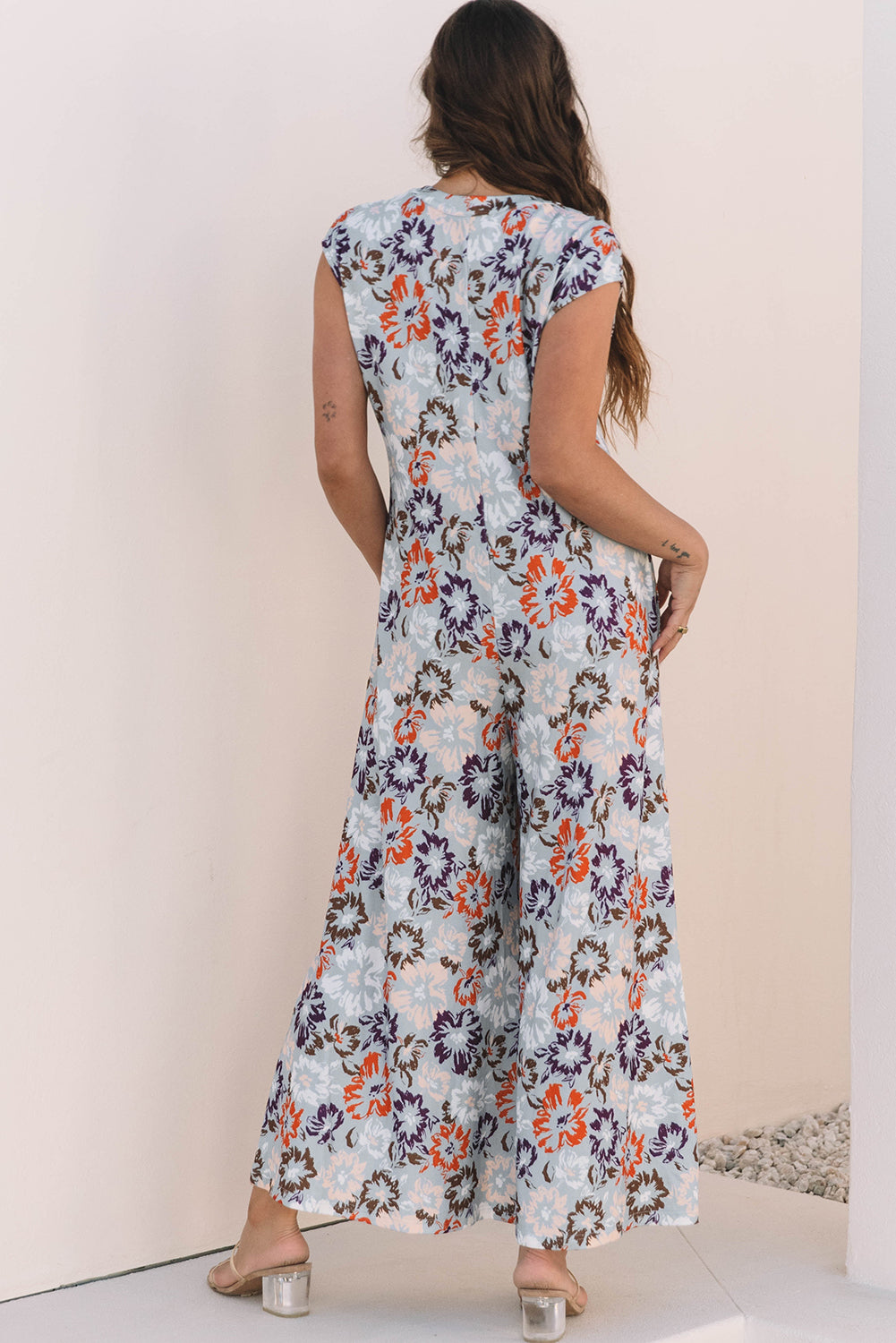 Floral sleeveless wide leg jumpsuit in blue with half button front and side pockets — view 2