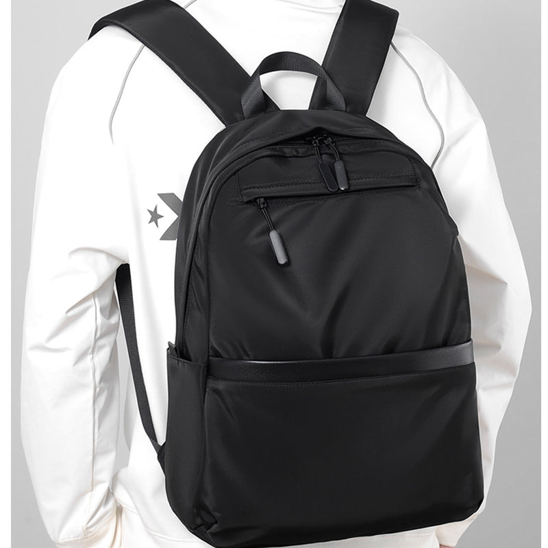 Minimalist black waterproof nylon laptop backpack with zippered pockets for urban commuting and travel