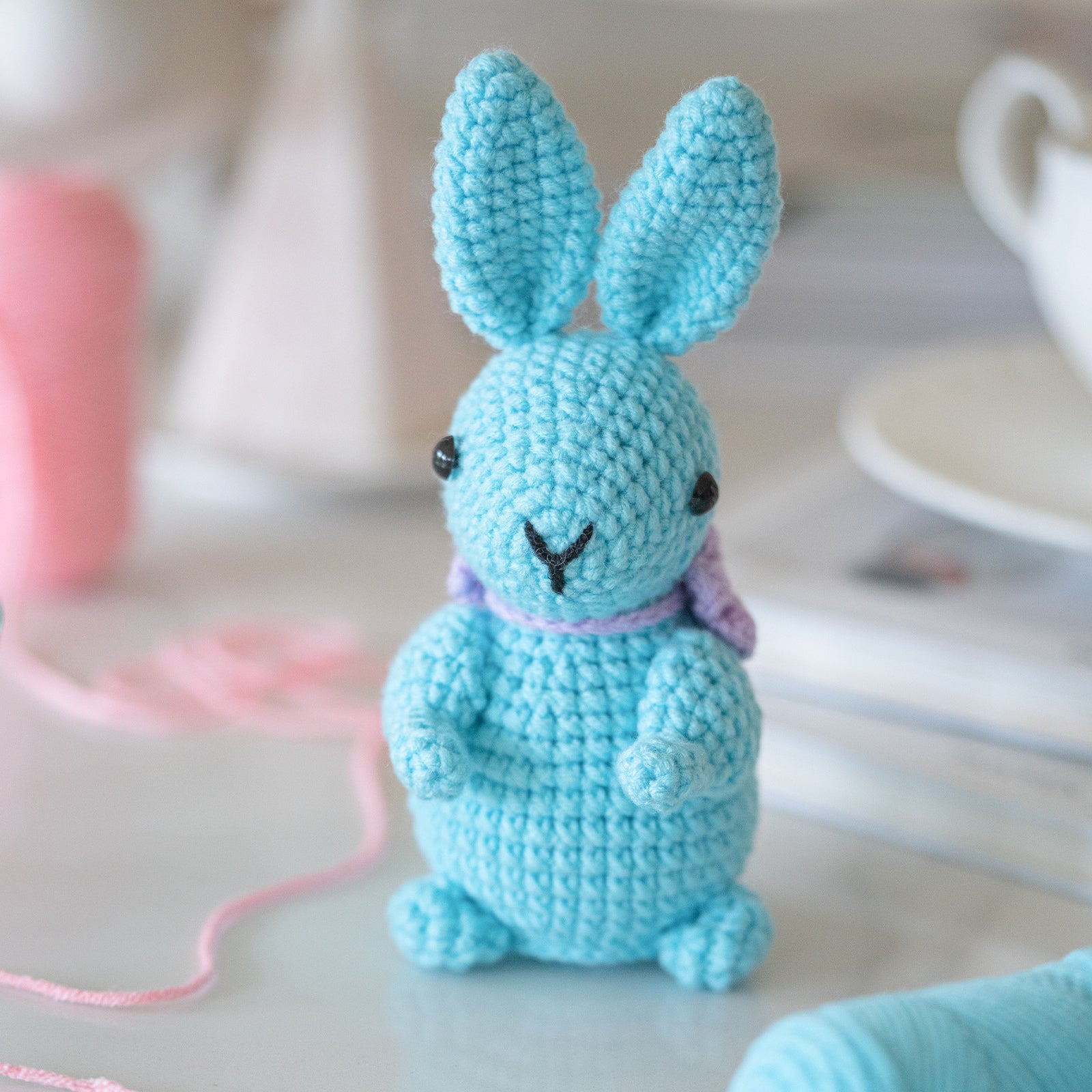 Rabbit amigurumi crochet kit showing finished plush bunny, premium threads, hook, and instructions — view 4